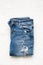 Folded blue jeans lie on a white background