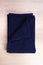 Folded blue navy towel on wooden background