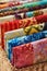 Folded bright pieces of quilting batik fabrics in a basket, macro