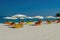 Folded colorful sea beds below sun umbrellas on an empty sandy beach in Chalkidiki Peninsula, Greece