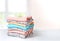 Folded cotton clothes stack on table empty background