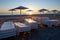 Folded deck chairs with umbrellas in the foreground. Deserted evening beach