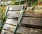 Folded garden chairs that lean against a fence on a rainy day