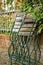 Folded garden chairs that lean against a fence on a rainy day