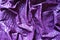 Folded glossy bright violet viscose fabric from above