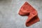 Folded linen napkin terracotta color on gray concrete table with copy space, top view