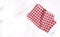 Folded red checkered cloth on white table top view.Picnic towel on kitchen table