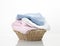 Folded towels stack in basket on white background,heap of colorful laundry on table