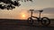 Folding bike with sunset background in a field