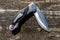 Folding knife on the rustic wooden background