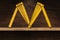 Folding Ruler in the Shape of Letter M on a Wooden Shelf