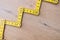 Folding zig zag ruler. Measuring tape folding yellow open in zigzag tips on a workbench. Measuring tools for carpenters and