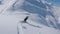 FOLLOW: Female snowboarder carving down the fresh powder snow in wintry Alps.