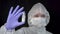 Follow focus Female scientist doctor virologist in white hazmat protection holding vaccine ampoule in hand, new medication develop