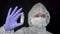 Follow focus Female scientist doctor virologist in white hazmat protection holding vaccine ampoule in hand, new medication develop