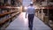 Follow footage of employees male warehouse worker engineer in hard hat working. walking through logistics center