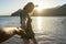 Follow of girlfriend in a summer dress running and holding boyfriend hand on the beach in sunset. Happy couple in honeymoon,