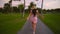 Follow me concept of young woman running on tropical golf course path. Summer vacation or holiday