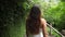 Follow Shot of Young Girl in White Dress Walking Jungle Forest Path and Looking Around. Calm and Carefree Lifestyle Travel 4K