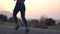 Follow to feet of young girl running at country road. Female leg jogging in nature. Sporty active lifestyle. Slow motion