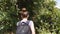 Follow to female hiker with backpack walks on the trail at tropical forest. Young backpacker explores green jungle at