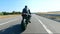 Follow to motorcyclist riding on modern sport motorbike at highway. Biker racing his motorcycle on country road. Guy
