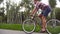 Follow to young handsome man riding a vintage bicycle outdoor. Sporty guy cycling at the park. Healthy active lifestyle