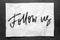 Follow us. Lettering on crumpled white paper. Handwritten text. Inspirational quotes.