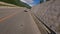 Follow view white sports car speed riding under bridge on serpentine road