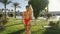 Following back shot of attractive young girl in red body swimsuit running from hotel room to swimming pool. Perfect sexy