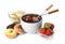 Fondue forks with strawberries in bowl of melted chocolate and other fruits on white background