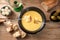 Fondue from melted cheese with bread on long forks, pickles and wine on a rustic wooden table, traditional new year dish from