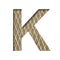 Font on a embossed metal sheet. The letter K is cut out of white paper on the background of a weathered sheet of metal with a