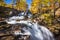 Fontcouverte Waterfall in Autumn with larch trees in the Claree Upper Valley. Hautes-Alpes, Alps, France