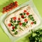 Food art. Focaccia, pizza, flat bread with vegetables, bright color green backdrop