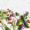 Food background. Assortment of fresh vegetables on a light background - zucchini, eggplant, peppers, beets, tomatoes, green