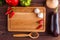 Food background with chopping board in spices and vegetables fra