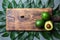 Food background with fresh avocado, avocado tree leaves and wooden cutting board. Harvest concept, Guacamole ingredients. Healthy