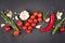 Food background - many seasonings, herbs and vegetables over dark concrete background