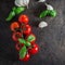 Food Background. Organic Cherry Tomatoes with basil and garlic on stone background. Top view
