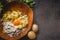 Food background with preparation potato  dough. Potatoes with egg and flour in wooden bowl on dark kitchen table with ingredients