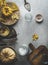 Food background with pumpkins, millet in bowl, cardamon spice and kitchen utensils on grey concrete kitchen table. Vegan cooking