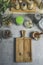 Food background with wooden cutting board, mortar and pestle, jars with ingredients and herbs at grey kitchen table. Cooking at