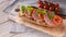 Food banner. Bruschetta with salami and tomatoes, cream cheese, pea microgreens and pesto sauce on a wooden cutting board