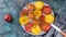 Food banner. Tasty red and yellow tomatoes with salt and spices on a round plate. Top view