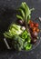 Food basket with fresh garden vegetables - beets, broccoli, eggplant, asparagus, peppers, tomatoes, cabbage on a dark table