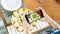 A food blogger takes pictures of an egg-shaped Easter sugar cookie on a smartphone. The influencer takes pictures of iced cookies