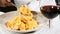 Food concept. Close up of male afro-american eating pasta with a spoon and a fork. a glass of wine is on table. Holiday