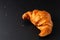 Food concept French croissant on black slate board with copy space