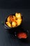 Food concept homemade organic Seasoned Baked Potato wedges in black bowl on black slate stone plate with copy space